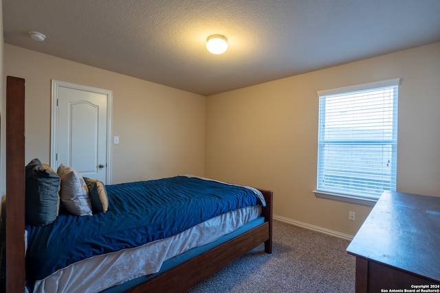 bedroom featuring a textured ceiling and carpet flooring