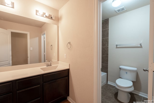 bathroom featuring toilet, vanity, and tile patterned flooring