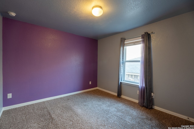 carpeted spare room with a textured ceiling