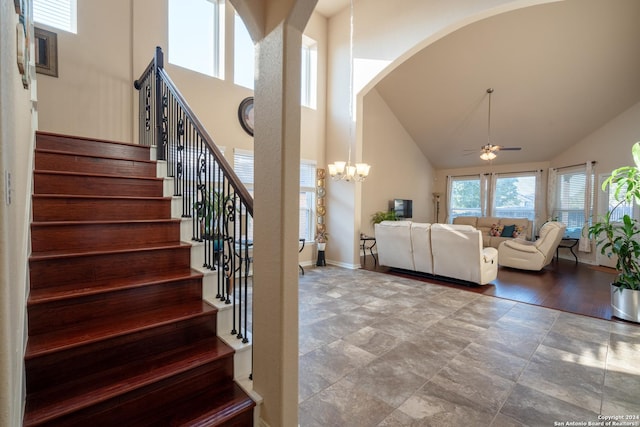 7527 Presidio Hvn, Boerne, TX 78015 - stairway featuring arched walkways, baseboards, high vaulted ceiling, and ceiling fan with notable chandelier