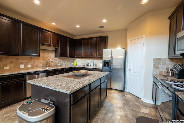 7527 Presidio Hvn, Boerne, TX 78015 - kitchen with a sink, visible vents, dark brown cabinetry, light stone counters, and appliances with stainless steel finishes