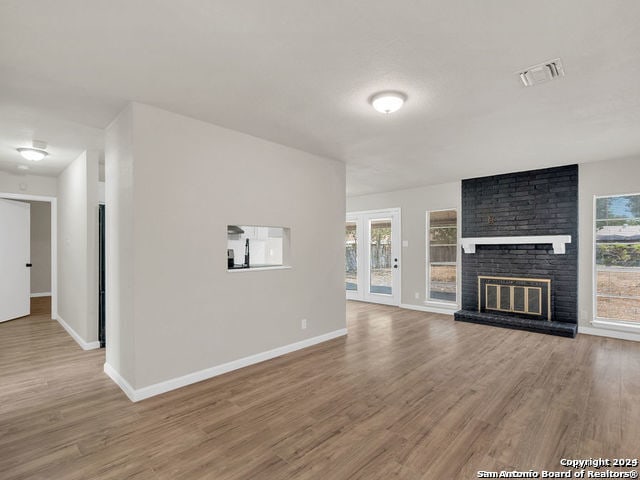 unfurnished living room with hardwood / wood-style floors and a fireplace