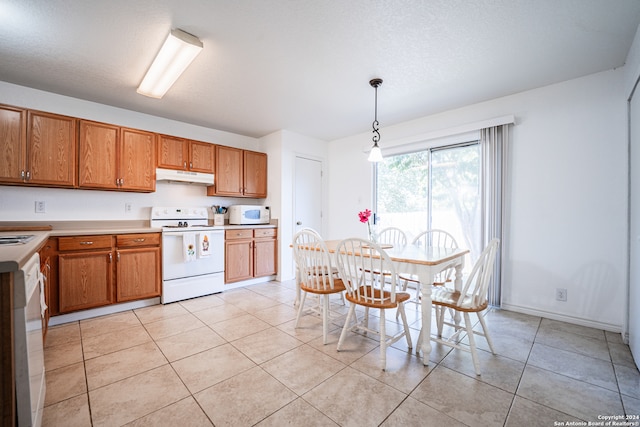 kitchen with hanging light fixtures, a textured ceiling, white appliances, and light tile patterned floors