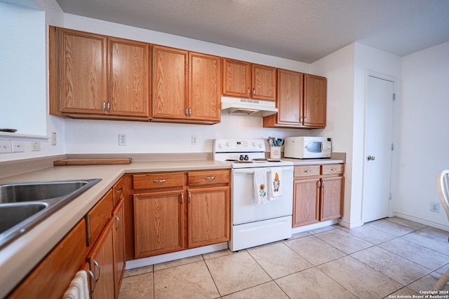 kitchen with a textured ceiling, light tile patterned floors, and white appliances