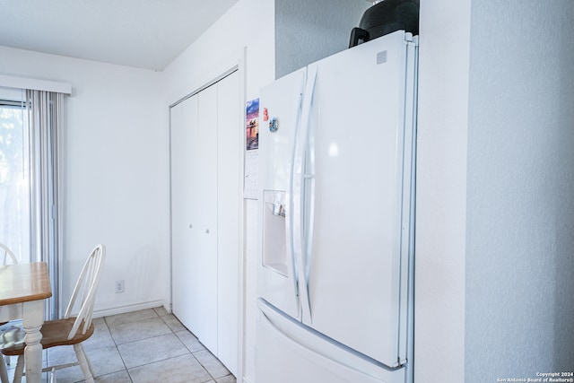 kitchen featuring white refrigerator with ice dispenser and light tile patterned floors