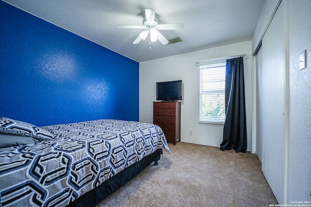 bedroom featuring a textured ceiling, carpet flooring, and ceiling fan