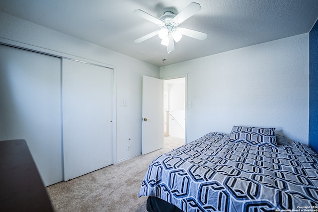 carpeted bedroom with a closet and ceiling fan