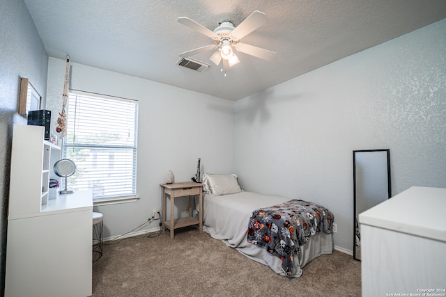 bedroom with carpet, a textured ceiling, and ceiling fan