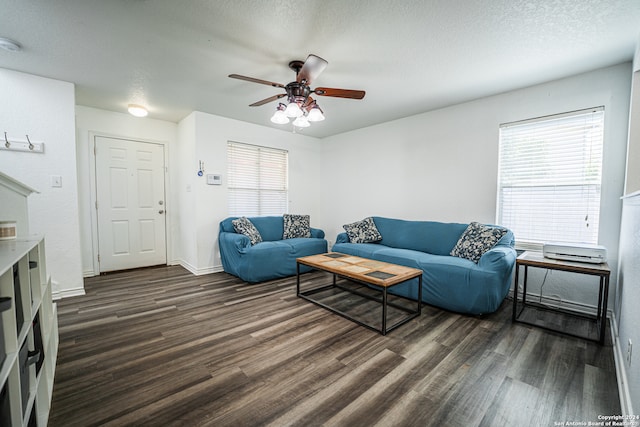 living room featuring a textured ceiling, a healthy amount of sunlight, dark wood-type flooring, and ceiling fan