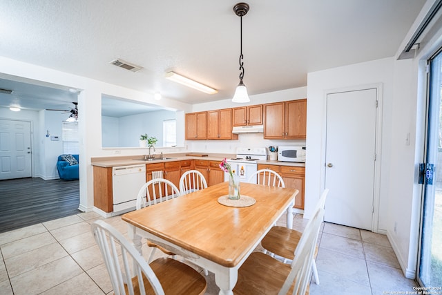 tiled dining space featuring ceiling fan, a textured ceiling, and sink