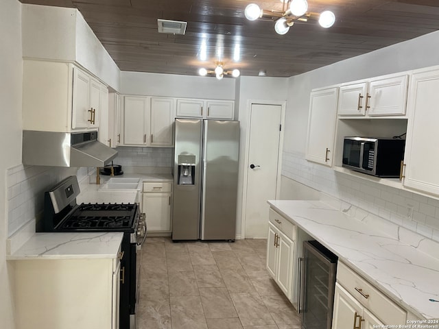 kitchen with decorative backsplash, stainless steel appliances, beverage cooler, and light stone counters