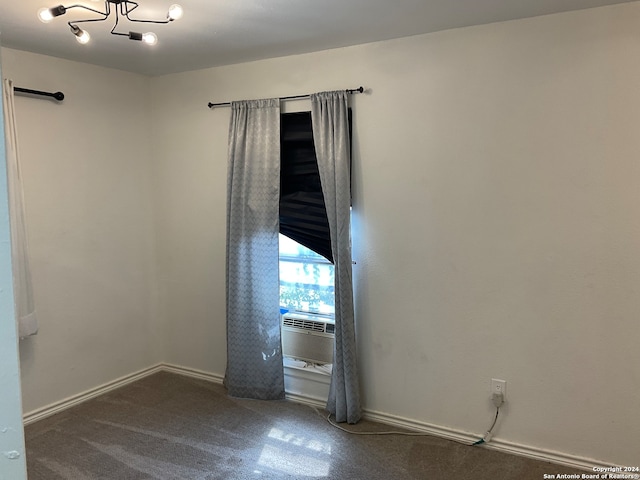 unfurnished room featuring dark carpet and cooling unit