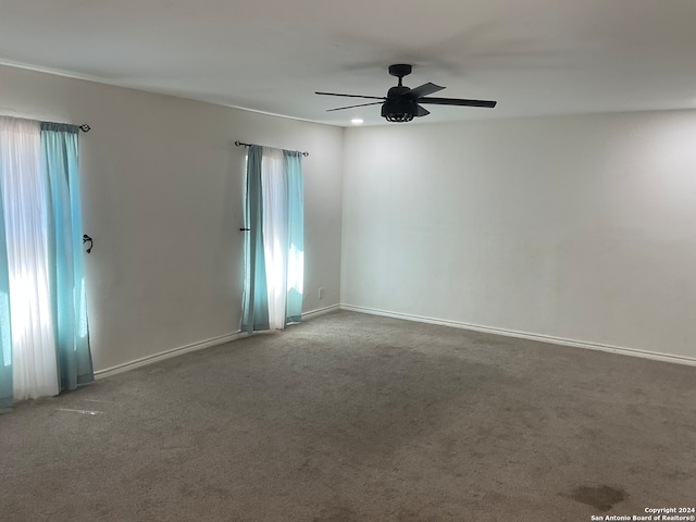 spare room featuring ceiling fan and carpet floors