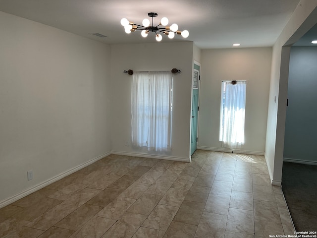 spare room with an inviting chandelier