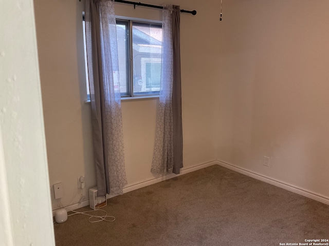 unfurnished room featuring dark colored carpet