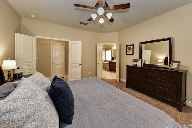 bedroom with ceiling fan, ensuite bathroom, and light colored carpet