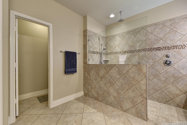 bathroom with a tile shower and tile patterned flooring