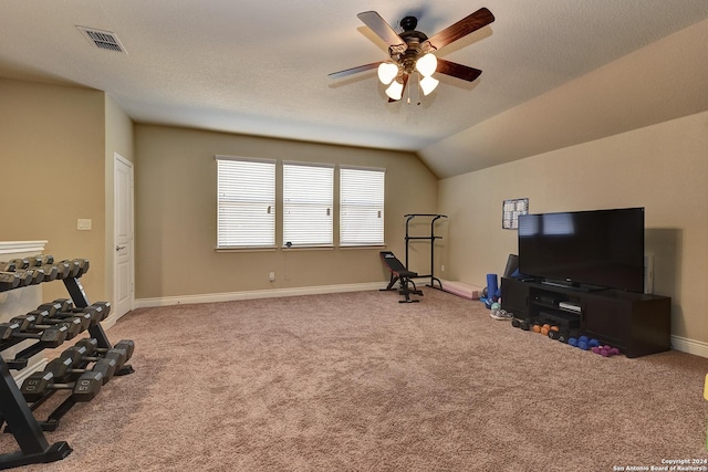 workout area with ceiling fan, a textured ceiling, vaulted ceiling, and carpet floors