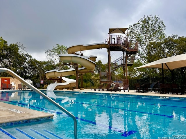 view of swimming pool with a water slide