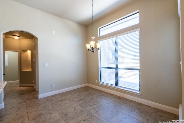 spare room featuring a chandelier