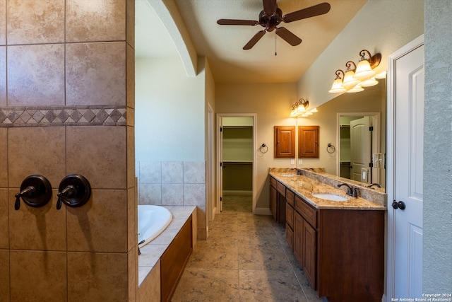 bathroom with vanity, tiled bath, and ceiling fan