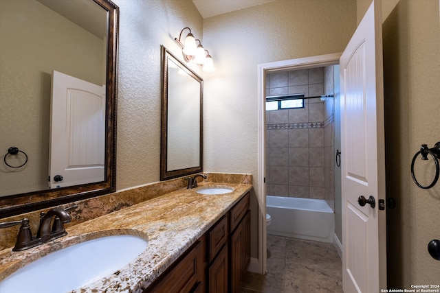 full bathroom with vanity, tiled shower / bath combo, and toilet