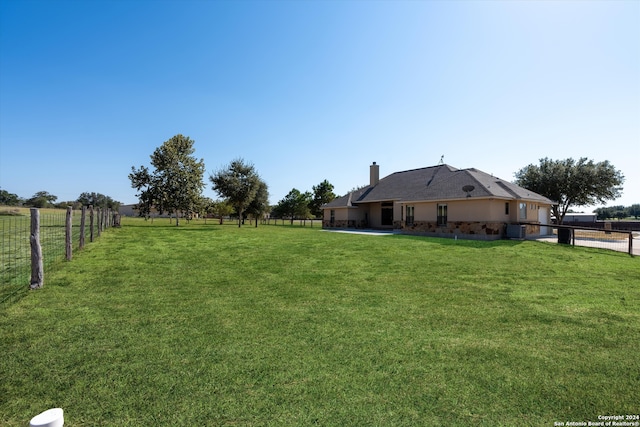 view of yard with central AC and a rural view