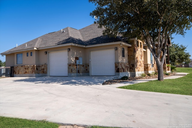 view of side of property featuring a garage and a lawn