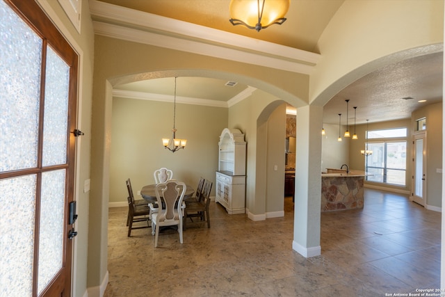 tiled dining space featuring sink, crown molding, and an inviting chandelier