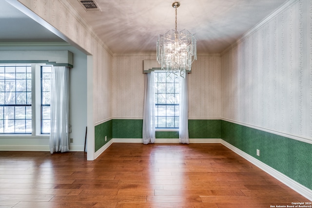 empty room with ornamental molding, hardwood / wood-style floors, and a healthy amount of sunlight