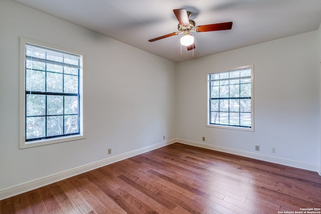 unfurnished room with hardwood / wood-style flooring, a healthy amount of sunlight, and ceiling fan