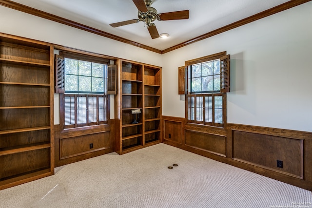 interior space with wooden walls, ornamental molding, plenty of natural light, and ceiling fan