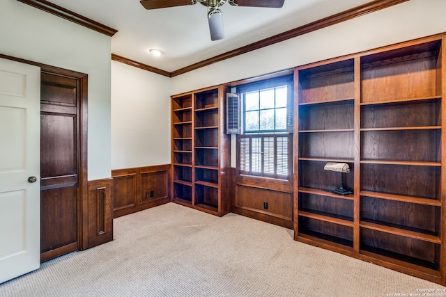 unfurnished office with wooden walls, light carpet, crown molding, and ceiling fan