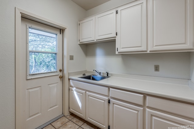 laundry area featuring sink and light tile patterned floors