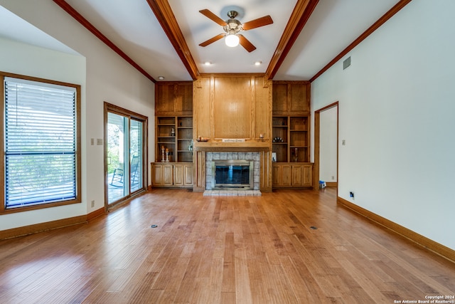 unfurnished living room with crown molding, a tiled fireplace, and light wood-type flooring