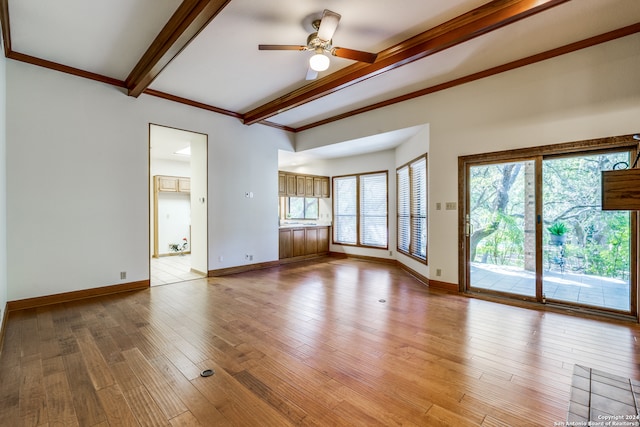 unfurnished living room with beam ceiling, light wood-type flooring, a healthy amount of sunlight, and ceiling fan