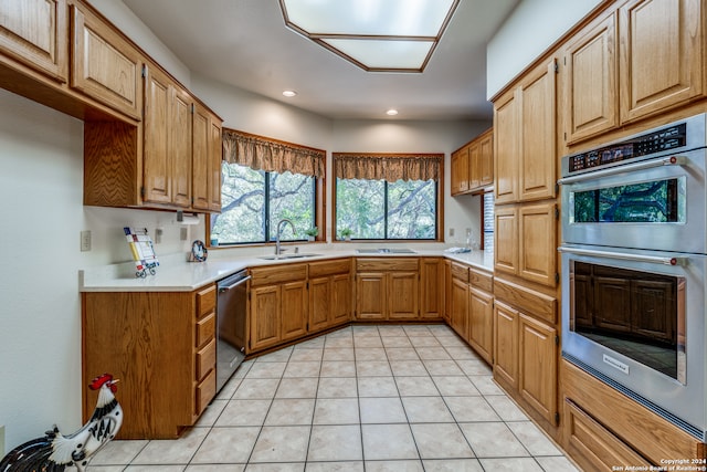 kitchen with sink, light tile patterned flooring, and stainless steel appliances