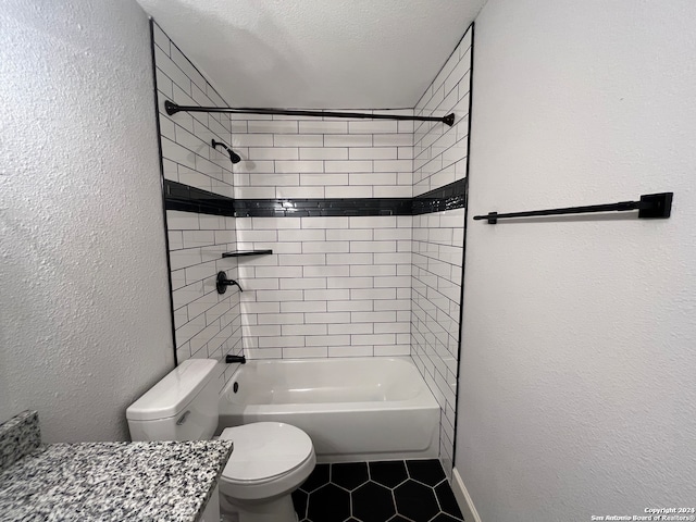 full bathroom featuring tiled shower / bath, a textured ceiling, toilet, vanity, and tile patterned flooring