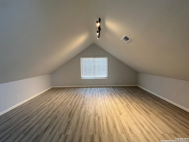 bonus room featuring vaulted ceiling and hardwood / wood-style flooring