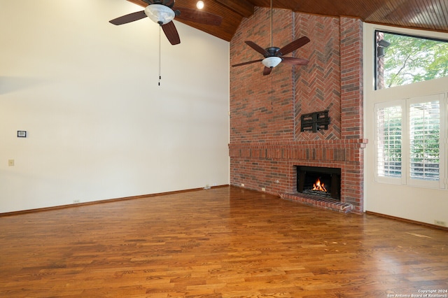 unfurnished living room featuring high vaulted ceiling, a healthy amount of sunlight, and wood-type flooring