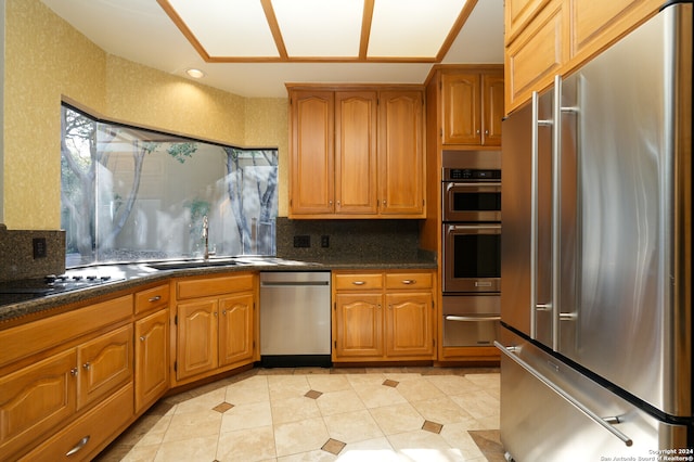 kitchen featuring sink, appliances with stainless steel finishes, decorative backsplash, and light tile patterned floors