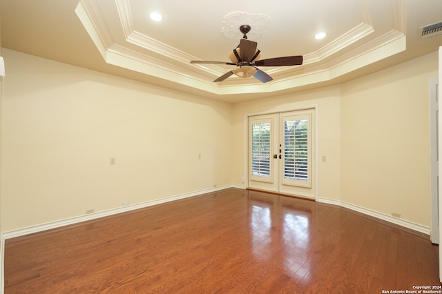 spare room with french doors, a raised ceiling, and hardwood / wood-style floors