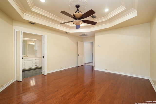 unfurnished room featuring crown molding, a tray ceiling, and dark hardwood / wood-style floors