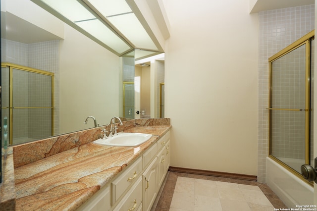 bathroom with vanity, bath / shower combo with glass door, and tile patterned flooring