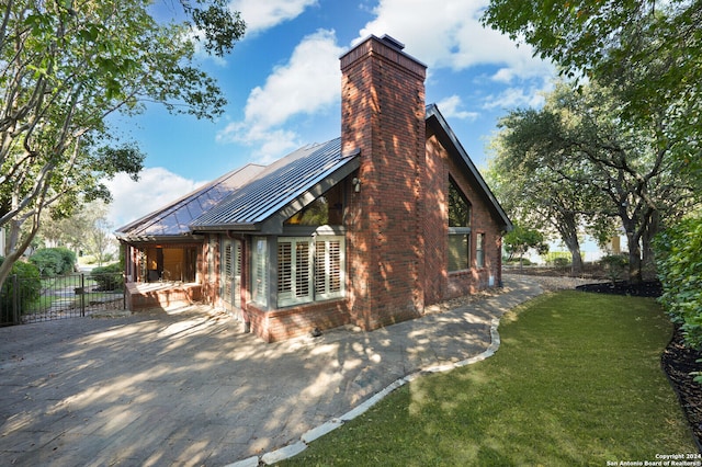 view of side of property with a yard and a patio