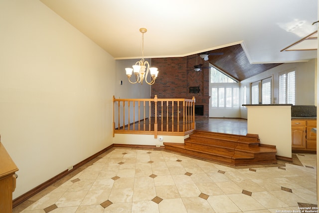 stairway with lofted ceiling, tile patterned flooring, brick wall, a fireplace, and ceiling fan with notable chandelier