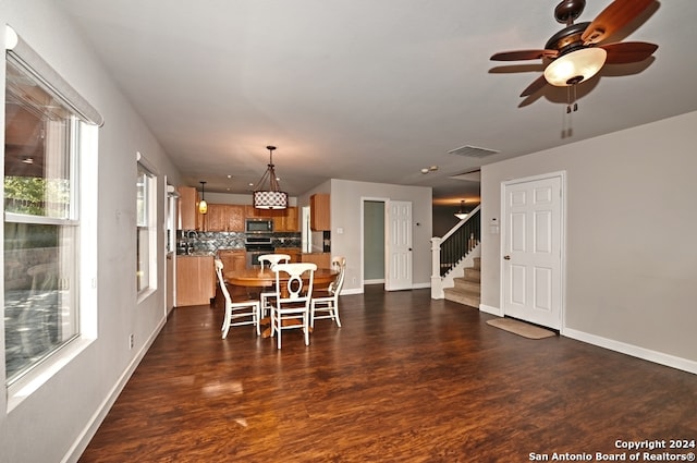 dining room featuring dark wood-type flooring, ceiling fan, and sink