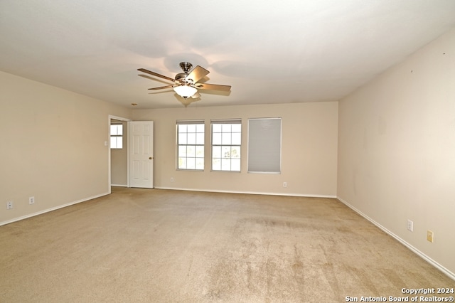 empty room with light colored carpet and ceiling fan