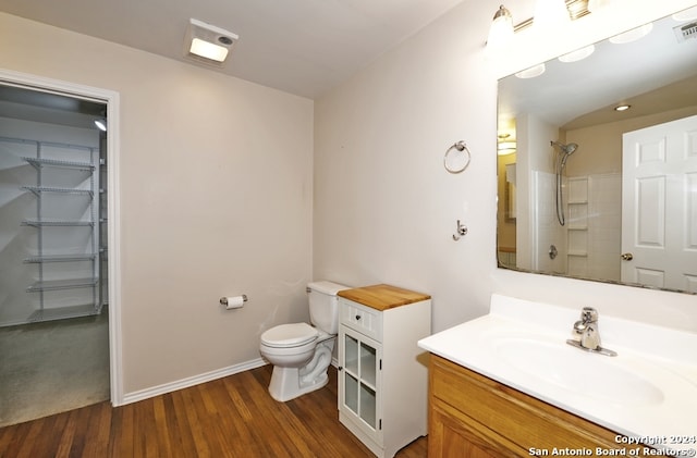 bathroom with vanity, hardwood / wood-style flooring, toilet, and walk in shower