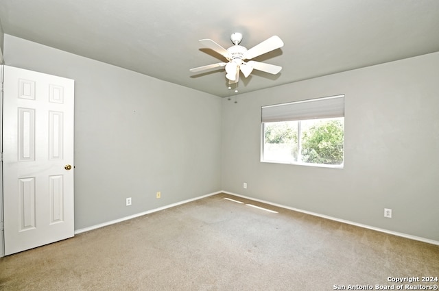 unfurnished room with light colored carpet and ceiling fan